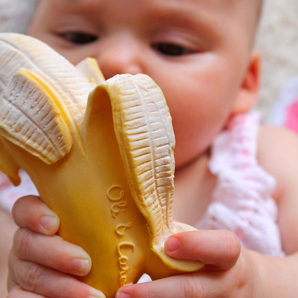 Image of a baby holding the Old & Carol Ana Banana teether