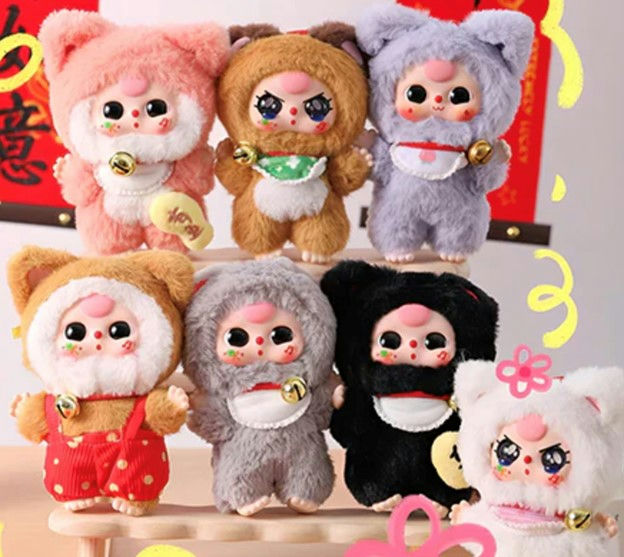 Set of cute plush toys with animal ears on a wooden stand against a colorful background. Baby Three Billionaire Cats.