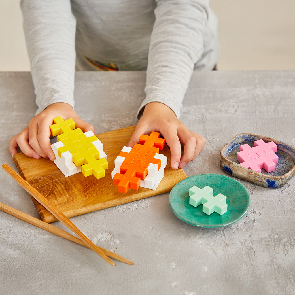 Child playing with colorful puzzle toy pieces on a wooden board.