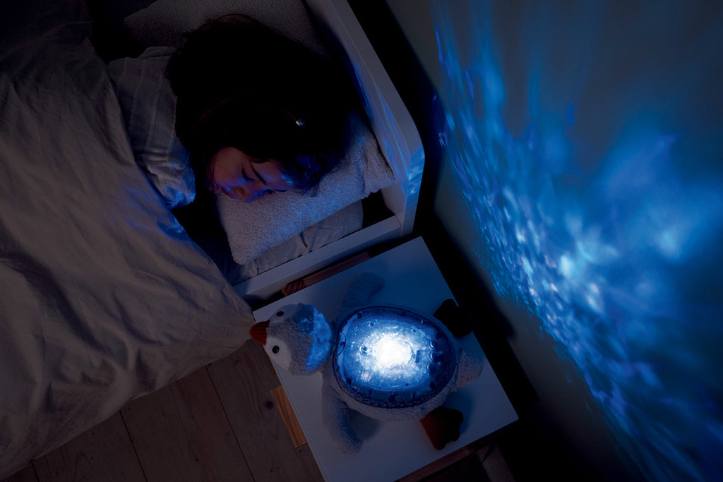 Person lying in bed with a night light and under water projection on the wall.