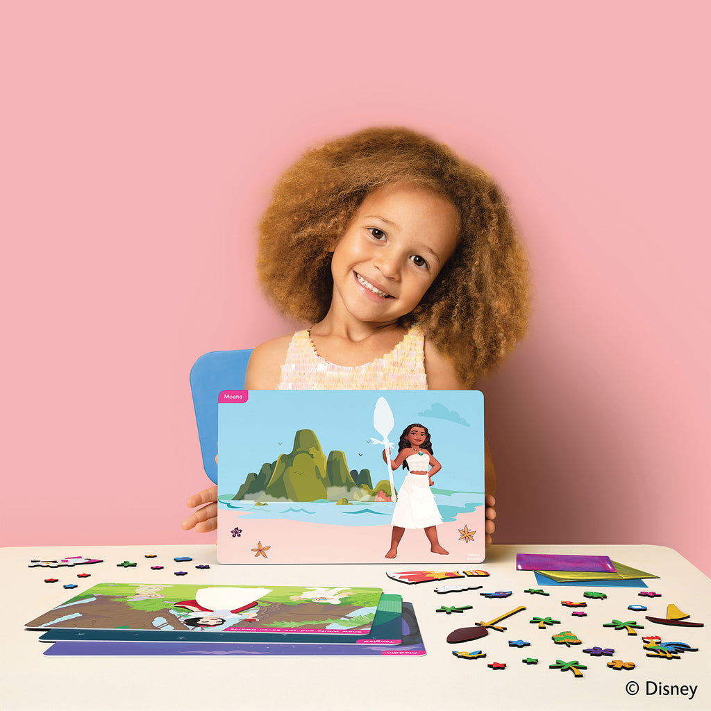 Child holding a Disney educational game with a pink background