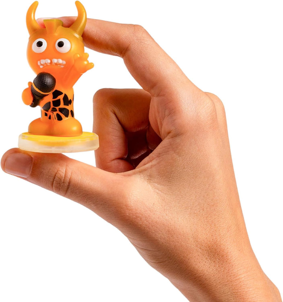 Hand holding a small orange figurine with horns and a microphone against a white background