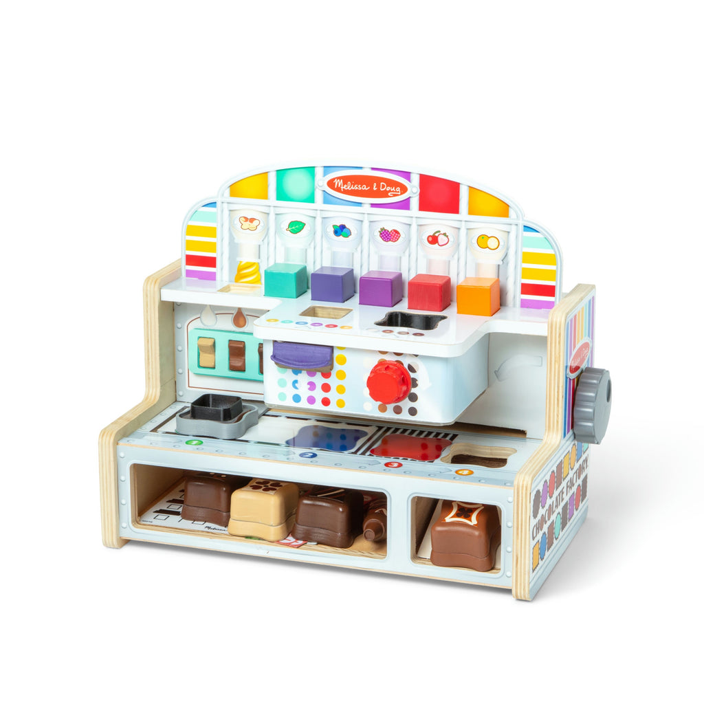 Colorful toy chocolate factory with various compartments on a white background