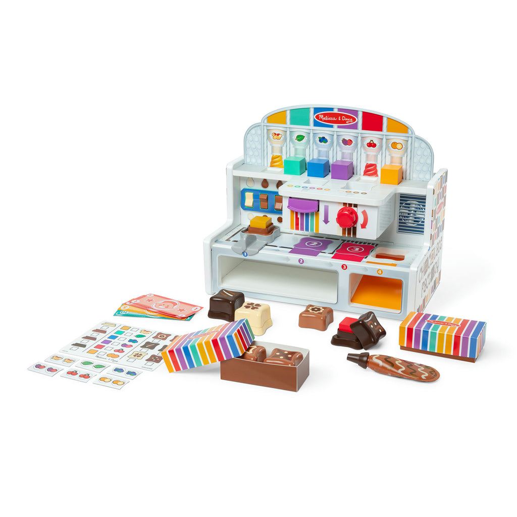 Toy chocolate factory set with various accessories on a white background