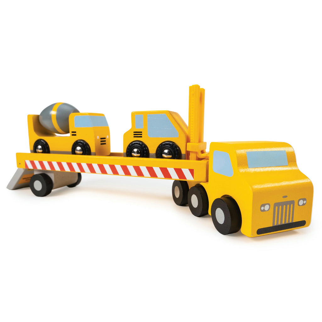 Toy construction vehicle with a trailer carrying another toy vehicle on a white background