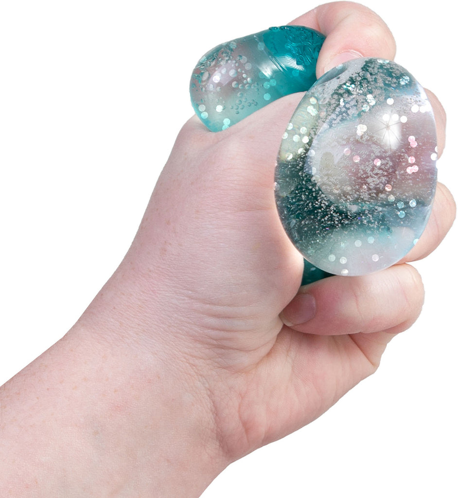 Hand holding a glittery blue stress ball against a white background