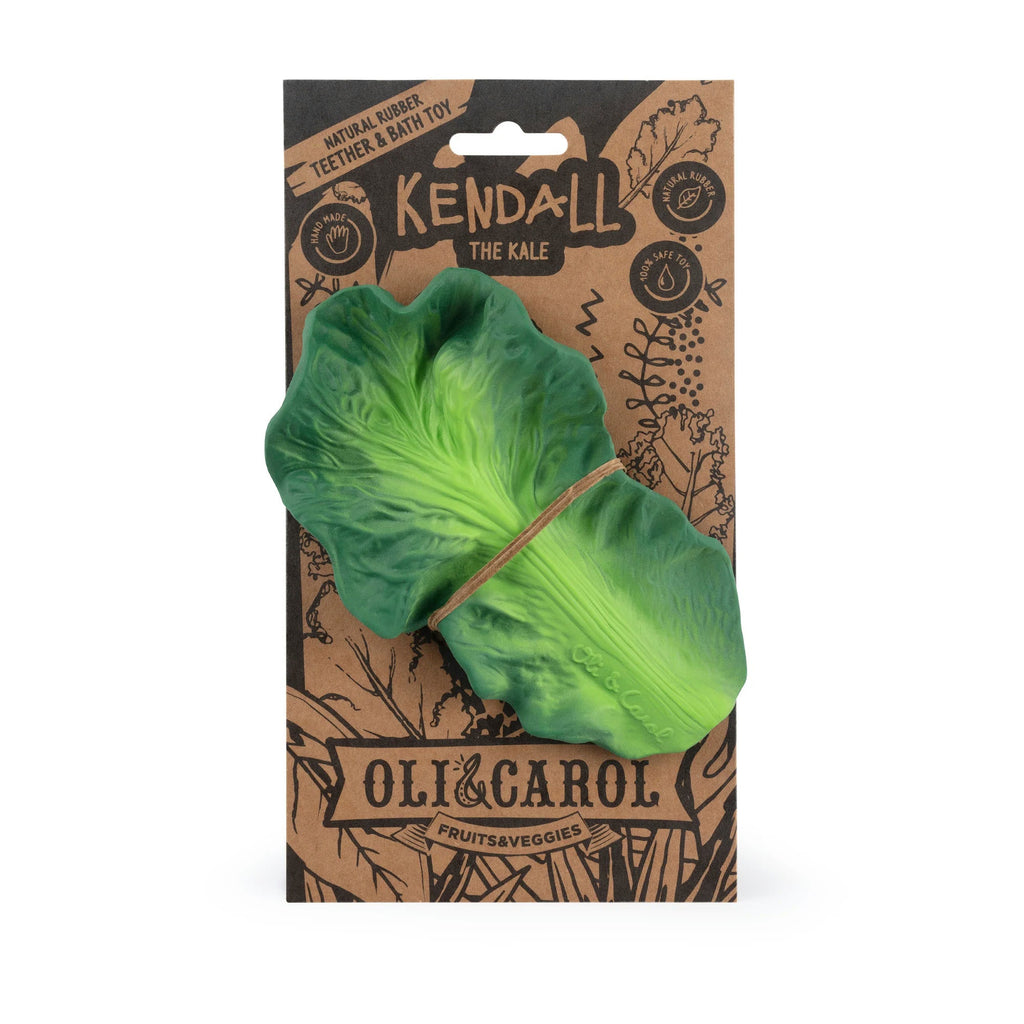 Green leaf-shaped toy with 'Kendall the Kale' branding on a brown package with 'Oli & Carol' branding.