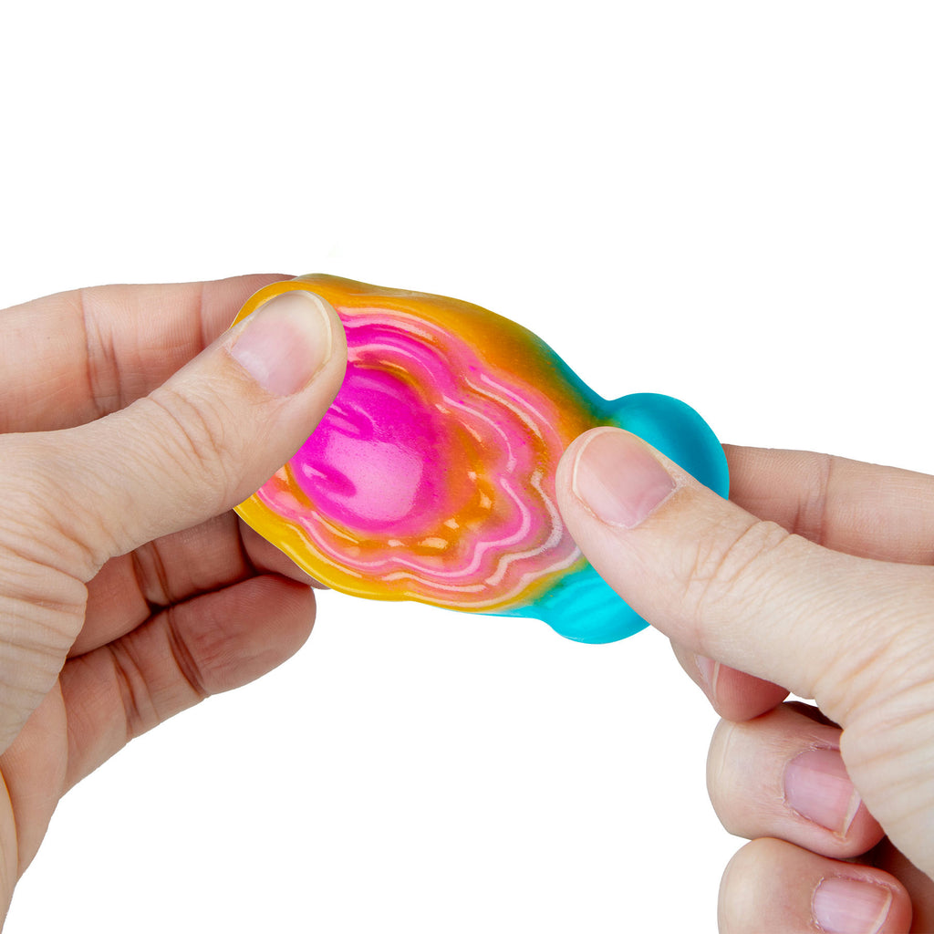 Colorful fidget spinner held between fingers on a white background