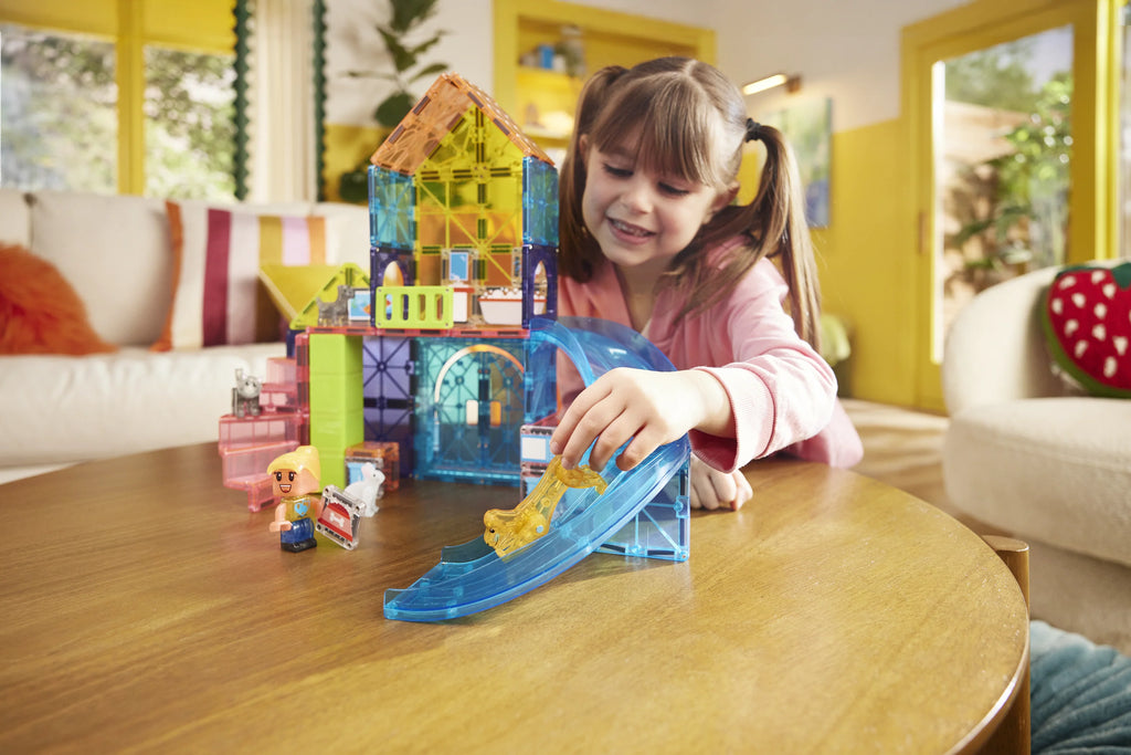 Child playing with colorful toy blocks on a wooden table in a living room.