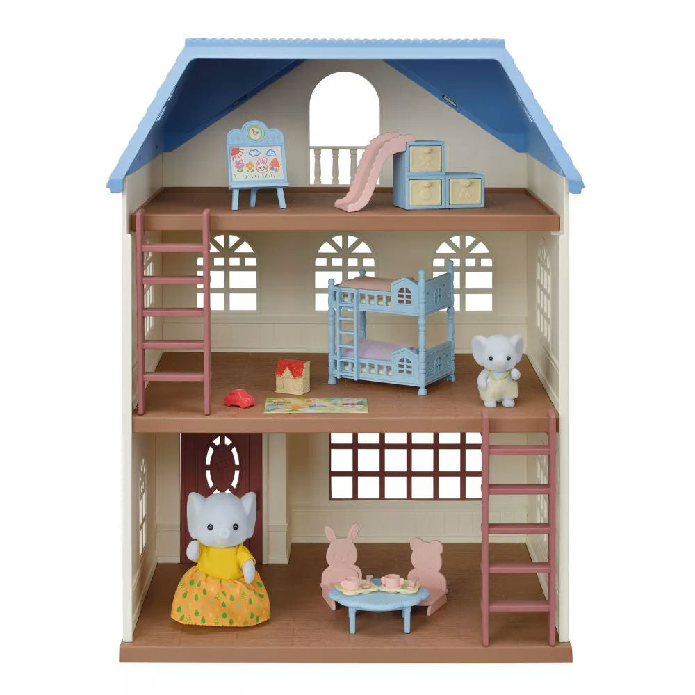 Calico Critters toy dollhouse with furniture and characters on a white background