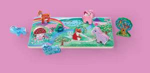 Image of puzzle back and pieces as a playset, whimsical scene with a pink backdrop.